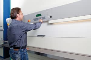 Worker operating vertical storage carousel to optimise warehouse storage in Singapore - TYT Corporation